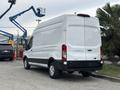 A white 2020 Ford Transit 250 van is parked with its rear facing the viewer showcasing its large cargo area and sliding side door