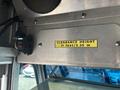 A metal sign displaying the clearance height of 11 feet 3.35 m mounted inside a vehicle with electrical components nearby