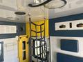 Interior view of a 2011 Chevrolet Express featuring a yellow and blue color scheme with overhead lights and straps for securing equipment