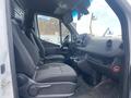 Interior view of a 2024 Mercedes-Benz Sprinter showing the driver and passenger seats and dashboard with controls
