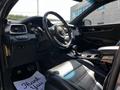 Interior view of a 2017 Kia Sorento featuring a black steering wheel leather seats and a console with controls and a gear shifter