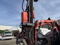 A 2018 Sandvik Ranger DX800 drill rig with a vertical drill mast and various hoses and cables connected to it