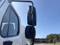 A side mirror of a 2014 Freightliner M2 106 positioned on the driver's side with a black casing and an adjustable arm
