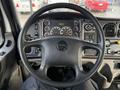 Steering wheel of a 2015 Freightliner M2 with various instrument gauges and controls visible on the dashboard