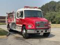 1999 Freightliner FL80 fire truck with a red and white color scheme lights on top and a shiny metal front grille