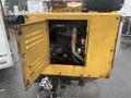 A 2010 Vermeer Corporation BC1000XL wood chipper with an open engine compartment revealing pipes and components inside