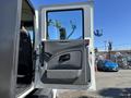 A wide-open door of a 2011 International 4300 revealing the vehicle's interior and driver's seat