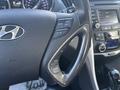 Close-up of the steering wheel and dashboard of a 2014 Hyundai Sonata with controls for cruise and audio settings visible
