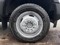 A close-up of a silver wheel rim and tire from a 2017 Ford F-550 showcasing the Cooper tire brand and the WORK SERIES label