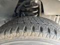Close-up of a worn tire showing tread patterns and part of the suspension system of a 2012 Ford Econoline