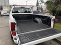 A 2011 Chevrolet Colorado pickup truck with an open bed featuring a spray-in bed liner and a tailgate partially lowered