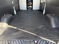 Interior view of a 2022 Ford Transit showing a spacious cargo area with a flat black floor and side walls designed for utility and storage purposes