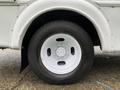 Close-up of a white wheel with a five-bolt pattern and black tire on a 2015 Chevrolet Express vehicle