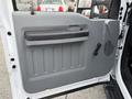 Interior door panel of a 2015 Ford F-350 featuring a gray finish with a black handle and a manual window crank