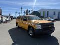 2013 Chevrolet Silverado 1500 in bright yellow with a checkered pattern on the side parked at an outdoor location
