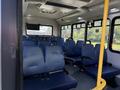 Interior view of a 2020 Chevrolet Express showing blue upholstered seats arranged in rows with a yellow pole for support