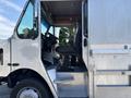 A 2008 Workhorse W62 featuring an open door showing the driver's seat and dashboard with various controls and a step leading up to the cabin