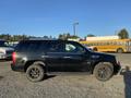 A black 2007 Cadillac Escalade parked on gravel showcasing its distinctive design and large wheels