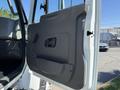 A close-up view of the door panel of a 2013 International 7400 showing its handle and armrest design