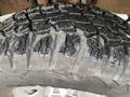 Close-up of a rugged tire with deep treads showcasing wear and dirt typical of off-road use