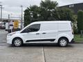 A white 2019 Ford Transit Connect van parked on a concrete surface with a sliding door and black trim on the side