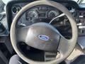The image shows the steering wheel and dashboard of a 2012 Ford Econoline with gauges and controls visible