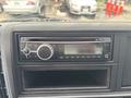 A Clarion car stereo mounted in the dashboard of a 2015 Mitsubishi Fuso FE160 with control knobs and display screen visible