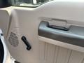 Interior door panel of a 2009 Ford F-550 featuring a handle and a manual window crank