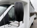 A close-up of the side mirror of a 2013 Chevrolet Express featuring a black plastic casing and a metal support arm