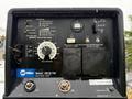 A control panel for a Miller Bobcat 200 Air Pak showing various dials and switches for compressor, generator, and weld settings