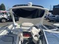 A 2013 Larson 238 boat featuring a spacious interior with white seating and a large canopy above