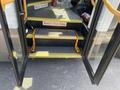 A 2020 Chevrolet Express with open doors revealing steps leading inside and a safety sign that says Watch Your Step