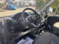 Interior of a 2022 RAM Promaster 350 featuring a steering wheel dashboard and gear shift with seating and control panels visible