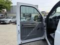 A 2011 Ford F-350 SD with an open driver side door showcasing the interior door panel and handle