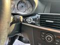 Interior view of a 2013 BMW X3 showing the steering wheel with control buttons a start stop button and climate control dials