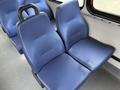 Two blue fabric seats designed for a bus, featuring a textured pattern and a black handle on the back of one seat