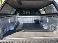 The image shows the interior of a 2014 Ford F-150 truck bed with a rubber mat and some storage space visible on the sides
