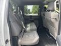 Interior view of the backseat of a 2017 Ford F-150 featuring two rows of seats with gray upholstery and seatbelts