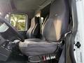 The interior of a 2013 International Durastar 4300 featuring two black fabric seats and a dashboard with control buttons and gear shift