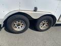 A close-up of two worn wheels on a 2008 Wells Industries Inc EW1422 trailer featuring rusted rims and flat tires