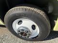 Close-up of a tire and wheel of a 1976 GMC Palm Beach with a white rim and silver lug nuts featuring a black GMC logo on the center cap