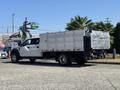 A 2019 Ford F-550 truck with a flatbed and metal sides parked on a street
