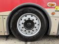 A large black tire mounted on a silver wheel with multiple lug nut holes showing the branding of the tire manufacturer and a prominent tread pattern