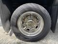 Close-up of a chrome wheel with a distinctive multi-spoke design mounted on a heavy-duty tire featuring visible tread patterns