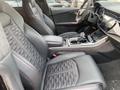 Interior view of a 2020 Audi RS featuring black leather bucket seats with intricate stitching a central console with controls and a digital display