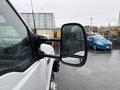 A 2000 Ford F-450 truck with a side mirror reflecting rain droplets