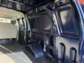 Interior view of a 2011 Ford Econoline van featuring a spacious cabin with metal paneling and a vinyl floor