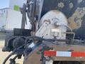 A close-up of a rusty winch and cable mechanism mounted on the rear of a 2014 International 7400 truck