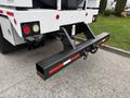 A 2016 Peterbilt 348 truck with a black tow hitch and red reflective stripes on the rear hitch assembly