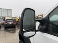 A 2006 Ford F-450 with a focus on its side mirror covered in raindrops